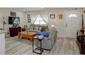 Cozy living room featuring wood-look floors, a comfortable gray sofa, and lots of natural light at 8795 56Th N St, Pinellas Park, FL 33782