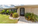 Inviting front entrance with lush landscaping and a well-manicured lawn at 949 Springview Nw Ave, Port Charlotte, FL 33948