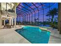 Indoor pool area with a hot tub and seating, encased in glass, with views of the water at 10580 Poughkeepsie Cir, Port Charlotte, FL 33981