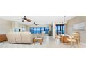 Bright living room featuring plush seating, ceiling fans, a dining area and stunning water views from expansive windows at 1750 Jamaica Way # 312, Punta Gorda, FL 33950