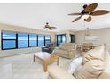 Inviting living room with plush seating, ceiling fans, a dining area and beautiful water views from the expansive windows at 1750 Jamaica Way # 312, Punta Gorda, FL 33950
