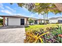 Well-maintained home featuring a large driveway, attached garage, and beautiful landscaping at 18753 Klingler Cir, Port Charlotte, FL 33948