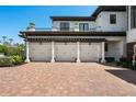 Three-car garage featuring white doors and brick-paved driveway at 2107 4Th Street W Ct, Palmetto, FL 34221