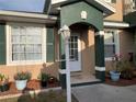 Charming front door and entry with green trim and matching potted plants at 224 Boundary Blvd # 224L, Rotonda West, FL 33947