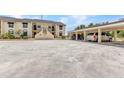 Unit's exterior featuring covered parking, assigned parking spaces, and walkway to the front door at 26461 Explorer Rd # F, Punta Gorda, FL 33983