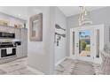 Bright foyer with decorative mirror and lighting fixtures leads into the kitchen with modern appliances and marble floors at 303 11Th E Ave, Palmetto, FL 34221