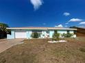 Well-kept single-story home with a blue exterior, white trim, and a manicured front yard at 4097 Rose Arbor Cir, Port Charlotte, FL 33948