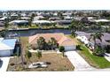 An exterior elevation showcases a well maintained home with a tile roof, two palm trees, and mature landscaping at 425 Belvedere Ct, Punta Gorda, FL 33950