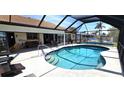 A beautiful in ground pool with steps and clear water surrounded by a screened in lanai with lounge furniture at 425 Belvedere Ct, Punta Gorda, FL 33950