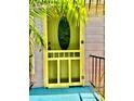 Inviting front door with decorative glass and vibrant yellow paint, enhancing the home's character at 4344 Commercial St, Port Charlotte, FL 33953
