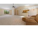 Bright living room featuring plush carpeting, a ceiling fan, and a cozy leather sofa at 453 Carolyn Ln, Punta Gorda, FL 33950