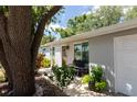 Side view of home featuring a covered entry way and well-manicured front yard at 5333 Simrak St, North Port, FL 34287