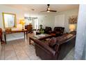 Inviting living room with comfortable leather furniture, ceiling fan and tile flooring at 5333 Simrak St, North Port, FL 34287