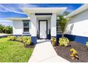 Inviting front entrance featuring manicured landscaping, a bright white door, and a covered porch at 6245 Alhambra Ave, North Port, FL 34291