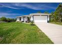 Well-maintained single-story home featuring a two-car garage, green lawn, and concrete driveway at 6245 Alhambra Ave, North Port, FL 34291