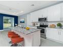 Modern kitchen featuring stainless steel appliances, granite countertops, and stylish orange barstools at 6245 Alhambra Ave, North Port, FL 34291