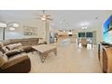 Spacious open-concept living area with tile flooring, a ceiling fan, and seamless flow to the kitchen at 7135 Tropicaire Blvd, North Port, FL 34291