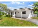 Cozy home with a covered front porch and driveway nestled on a grassy lot at 815 Papaya Dr, Tampa, FL 33619
