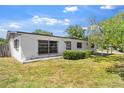 Quaint white home with a covered entry, security bars, and a lush green lawn at 815 Papaya Dr, Tampa, FL 33619