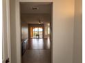 Hallway view leading into a living room with hardwood floors and sliding glass doors to the outside balcony at 99 Vivante Blvd # 311, Punta Gorda, FL 33950