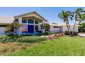 Beautiful home with a vibrant blue double-door entry and well-maintained landscaping at 12439 Prather Ave, Port Charlotte, FL 33981