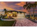 Beautiful home with well-manicured landscaping, brick driveway and a picturesque sunset at 1255 Eider Ct, Punta Gorda, FL 33950