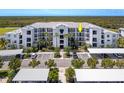 Condo building with a white exterior, parking, palm trees, and landscape at 14051 Heritage Landing Blvd # 536, Punta Gorda, FL 33955