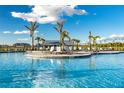 View of community pool with chairs, and palm trees under a bright blue sky at 14051 Heritage Landing Blvd # 536, Punta Gorda, FL 33955