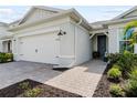 Exterior of a charming home with a two-car garage, paver driveway, manicured landscaping and attractive front entrance at 15830 Appalachian Dr, Punta Gorda, FL 33982
