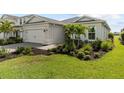 A lovely home featuring an attached two-car garage, beautiful landscaping with mature palm trees and a well-maintained lawn at 15830 Appalachian Dr, Punta Gorda, FL 33982