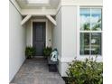 Inviting home exterior features a front door with a decorative seating area, manicured bushes and plenty of natural light at 15830 Appalachian Dr, Punta Gorda, FL 33982