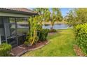 A serene backyard with lush greenery, swaying palms, and a tranquil pond view from the screened-in porch at 1745 Hyssop Loop, North Port, FL 34289