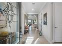Inviting foyer with archways, neutral tones, decorative glass door, and elegant console table at 1745 Hyssop Loop, North Port, FL 34289