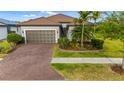 Charming single-story home featuring a brick driveway, well-manicured landscaping, and a neutral color scheme at 1745 Hyssop Loop, North Port, FL 34289