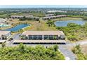 Aerial view showcasing the condo buildings, parking, and surrounding ponds and green spaces in the community at 175 Kings Hwy # 1114, Punta Gorda, FL 33983