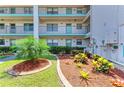 Exterior building view features well maintained landscaping and colorful plants by the condo units at 175 Kings Hwy # 1114, Punta Gorda, FL 33983