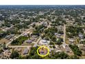 Aerial view of a neighborhood featuring a home with a screened in pool, surrounded by lush greenery at 21080 Firwood Ter, Port Charlotte, FL 33954