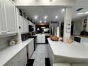 Spacious kitchen featuring a serving bar, quartz countertops, and stainless appliances at 25188 Marion Ave # 1004, Punta Gorda, FL 33950