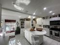 Bright kitchen with island, white cabinets, skylight and modern appliances at 25188 Marion Ave # 1004, Punta Gorda, FL 33950