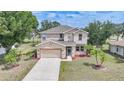 Aerial view of a charming two-story home with a two-car garage and lush lawn at 26100 Paysandu Dr, Punta Gorda, FL 33983