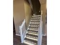 Modern staircase with wooden steps, white banister, and built-in accent lighting at 26100 Paysandu Dr, Punta Gorda, FL 33983