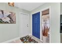 Inviting entryway with neutral walls, a blue door, decorative accents, and a stylish seashell themed rug at 318 Spring Lake Nw Blvd, Port Charlotte, FL 33952