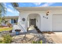 Welcoming front entrance featuring a textured archway, well-maintained landscaping, and stylish exterior lighting at 318 Spring Lake Nw Blvd, Port Charlotte, FL 33952