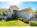 Stylish single-story home with manicured lawn, mature landscaping, and a brick-paved driveway leading to a two-car garage at 4992 Brittain Way, North Port, FL 34287