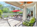 Screened-in patio with brick flooring, ceiling fan, patio set, and hot tub with view to interior living area at 4992 Brittain Way, North Port, FL 34287