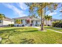 Charming single-story home boasts a manicured lawn, walkway, mature trees, and covered porch seating at 526 Allen St, Punta Gorda, FL 33950