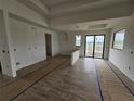Spacious living room with wood-look tile flooring, large sliding glass doors, and natural light at 7 Sunflower Dr, Placida, FL 33946