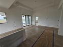 Open-concept living area featuring neutral walls, wood-look tile flooring, and sliding glass doors at 7 Sunflower Dr, Placida, FL 33946