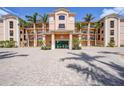 Elegant building exterior showcases lush landscaping, a grand entrance, and convenient parking at 95 N Marion Ct # 135, Punta Gorda, FL 33950