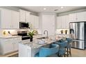 Modern kitchen features white cabinets, stainless steel appliances, granite countertops, and island with seating at 1132 Moss Cove Ct, Port Charlotte, FL 33953